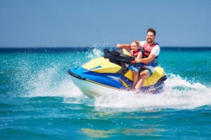 A father and sun riding a jet ski in Key West in the summer